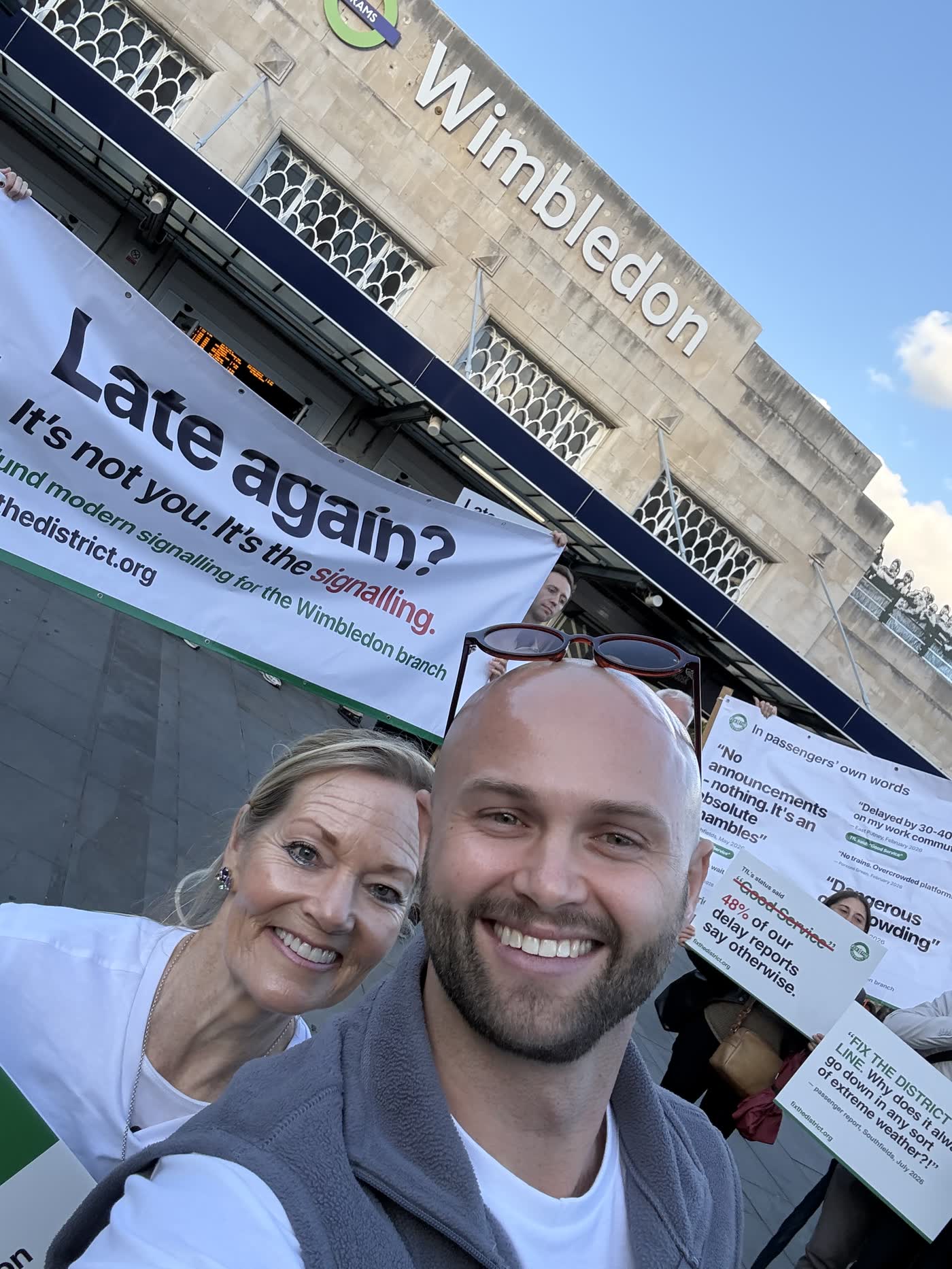 Campaigners in front of the quote wall of passenger reports, including “No announcements — nothing. It’s an absolute shambles.”